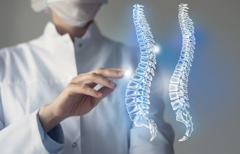 Orthopedic doctor pointing at virtual imagaes of spine