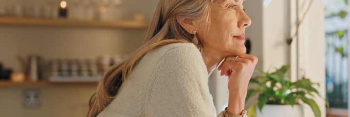 Window, smile and elderly woman with thinking at home for retirement, satisfaction and peace on weekend. Relax, senior person and calm with idea for reflection, mindfulness and good memory in house
